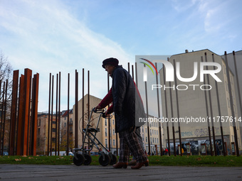 People walk by Berlin Wall remains at Berlin Wall Memorial during the 35th anniversary of the fall of the Berlin Wall. Berlin, Germany on 9...