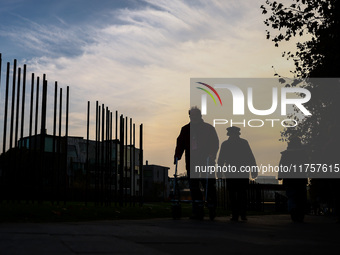 People walk by Berlin Wall remains at Berlin Wall Memorial during the 35th anniversary of the fall of the Berlin Wall. Berlin, Germany on 9...