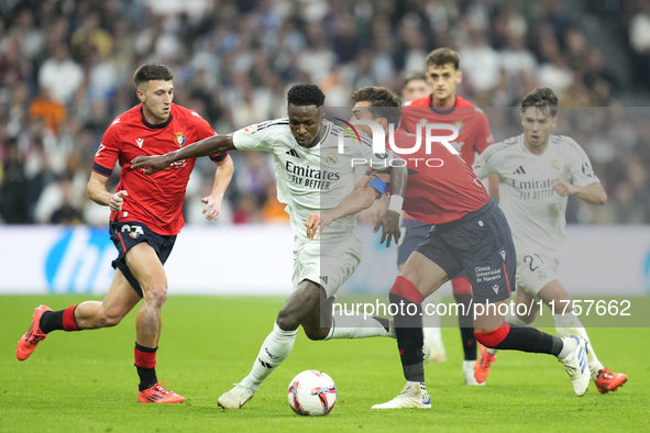 Vinicius Junior left winger of Real Madrid and Brazil and Lucas Torro defensive midfield of Osasuna and Spain compete for the ball during th...