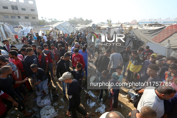 Palestinians inspect the site of an Israeli strike on a tent housing displaced people at Al-Aqsa Martyrs Hospital in Deir Al-Balah, in the c...