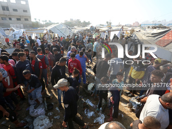 Palestinians inspect the site of an Israeli strike on a tent housing displaced people at Al-Aqsa Martyrs Hospital in Deir Al-Balah, in the c...