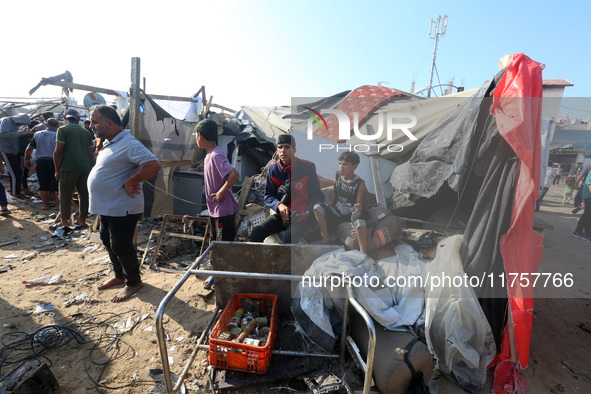 Palestinians inspect the site of an Israeli strike on a tent housing displaced people at Al-Aqsa Martyrs Hospital in Deir Al-Balah, in the c...