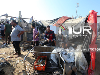 Palestinians inspect the site of an Israeli strike on a tent housing displaced people at Al-Aqsa Martyrs Hospital in Deir Al-Balah, in the c...