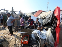 Palestinians inspect the site of an Israeli strike on a tent housing displaced people at Al-Aqsa Martyrs Hospital in Deir Al-Balah, in the c...