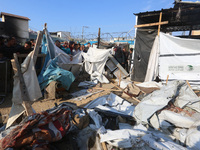 Palestinians inspect the site of an Israeli strike on a tent housing displaced people at Al-Aqsa Martyrs Hospital in Deir Al-Balah, in the c...