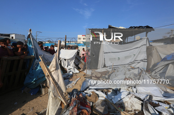 Palestinians inspect the site of an Israeli strike on a tent housing displaced people at Al-Aqsa Martyrs Hospital in Deir Al-Balah, in the c...