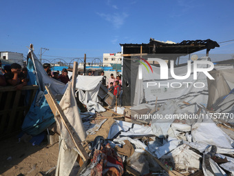 Palestinians inspect the site of an Israeli strike on a tent housing displaced people at Al-Aqsa Martyrs Hospital in Deir Al-Balah, in the c...