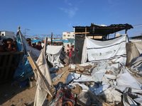 Palestinians inspect the site of an Israeli strike on a tent housing displaced people at Al-Aqsa Martyrs Hospital in Deir Al-Balah, in the c...