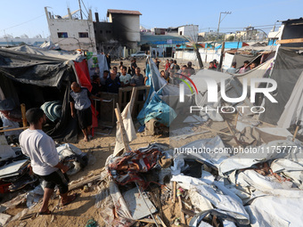 Palestinians inspect the site of an Israeli strike on a tent housing displaced people at Al-Aqsa Martyrs Hospital in Deir Al-Balah, in the c...