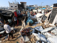 Palestinians inspect the site of an Israeli strike on a tent housing displaced people at Al-Aqsa Martyrs Hospital in Deir Al-Balah, in the c...