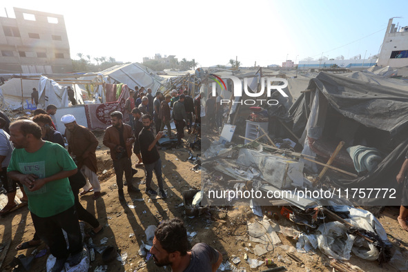 Palestinians inspect the site of an Israeli strike on a tent housing displaced people at Al-Aqsa Martyrs Hospital in Deir Al-Balah, in the c...