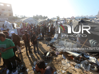 Palestinians inspect the site of an Israeli strike on a tent housing displaced people at Al-Aqsa Martyrs Hospital in Deir Al-Balah, in the c...