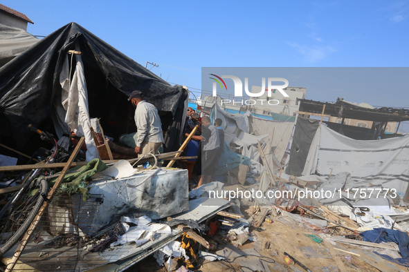 Palestinians inspect the site of an Israeli strike on a tent housing displaced people at Al-Aqsa Martyrs Hospital in Deir Al-Balah, in the c...