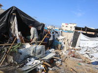 Palestinians inspect the site of an Israeli strike on a tent housing displaced people at Al-Aqsa Martyrs Hospital in Deir Al-Balah, in the c...