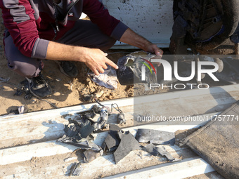 Palestinians inspect the site of an Israeli strike on a tent housing displaced people at Al-Aqsa Martyrs Hospital in Deir Al-Balah, in the c...