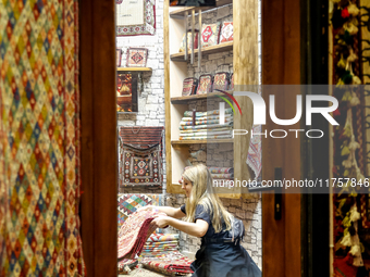 A woman browse Azeri carpets in a carper shop in an Old Town of Baku, Azerbaijan on November 9, 2024. (