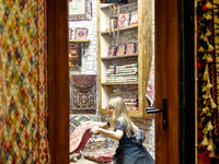 A woman browse Azeri carpets in a carper shop in an Old Town of Baku, Azerbaijan on November 9, 2024. (