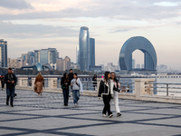 People walk on Caspian Sea Boulevard in Baku in front of landmark architecture, Azerbaijan on November 9, 2024. (