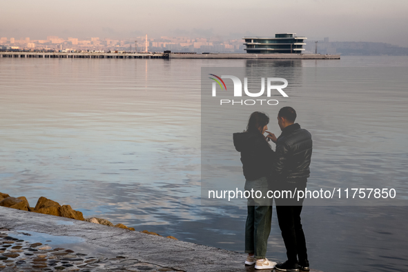 A couple stands on Caspian Sea Boulevard in Baku, Azerbaijan on November 9, 2024. 