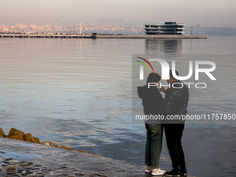 A couple stands on Caspian Sea Boulevard in Baku, Azerbaijan on November 9, 2024. (