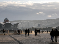 People walk on Caspian Sea Boulevard in Baku in front of landmark architecture, Azerbaijan on November 9, 2024. (