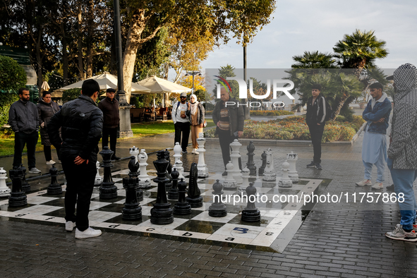 Men play chess on an outdoor board on Caspian Sea Boulevard in Baku, Azerbaijan on November 9, 2024. 