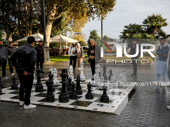 Men play chess on an outdoor board on Caspian Sea Boulevard in Baku, Azerbaijan on November 9, 2024. (