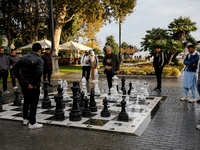 Men play chess on an outdoor board on Caspian Sea Boulevard in Baku, Azerbaijan on November 9, 2024. (