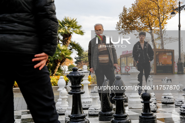 Men play chess on an outdoor board on Caspian Sea Boulevard in Baku, Azerbaijan on November 9, 2024. 