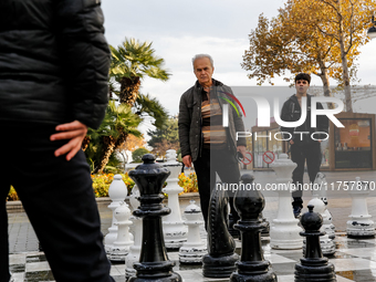 Men play chess on an outdoor board on Caspian Sea Boulevard in Baku, Azerbaijan on November 9, 2024. (