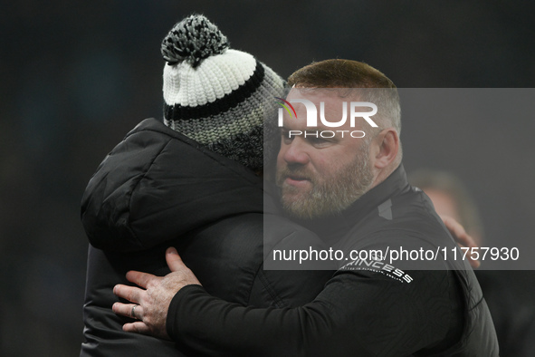 Wayne Rooney, manager of Plymouth Argyle, hugs Derby manager Paul Warne during the Sky Bet Championship match between Derby County and Plymo...