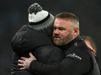 Wayne Rooney, manager of Plymouth Argyle, hugs Derby manager Paul Warne during the Sky Bet Championship match between Derby County and Plymo...