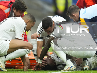 Eder Militao centre-back of Real Madrid and Brazil dejected after his injury is consoled by his teammates during the La Liga match between R...