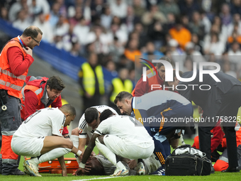 Eder Militao centre-back of Real Madrid and Brazil dejected after his injury is consoled by his teammates during the La Liga match between R...