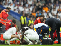 Eder Militao centre-back of Real Madrid and Brazil dejected after his injury is consoled by his teammates during the La Liga match between R...