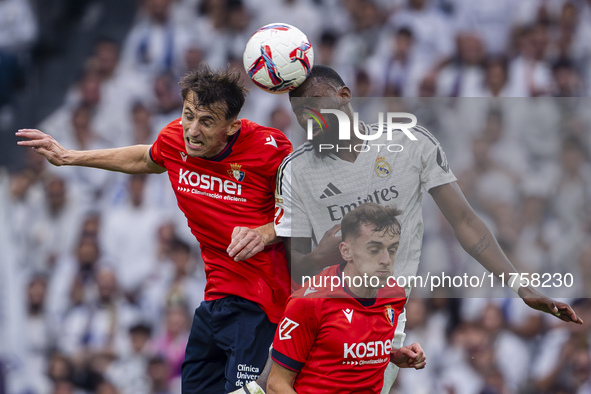 Antonio Rudiger of Real Madrid CF heads the ball between Ante Budimir and Aimar Oroz of CA Osasuna during the La Liga EA Sports 2024/25 foot...