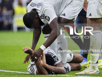 Eder Militao of Real Madrid CF is injured on the ground and is helped by his teammate Antonio Rudiger of Real Madrid CF during the La Liga E...