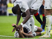 Eder Militao of Real Madrid CF is injured on the ground and is helped by his teammate Antonio Rudiger of Real Madrid CF during the La Liga E...