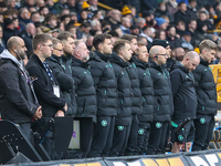 Wolves playing staff observe a minute's silence as they pay their respects to the fallen during the Premier League match between Wolverhampt...