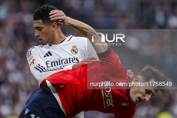 Jude Bellingham of Real Madrid CF (L) is in action against Ante Budimir of CA Osasuna (R) during the La Liga EA Sports 2024/25 football matc...