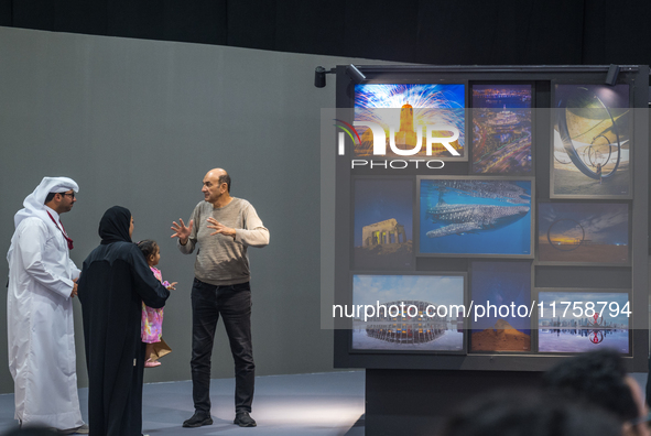 People look at photographs on display during the inaugural Doha Photography Festival 2024 at Darb al-Saai in Umm Salal, Qatar, on November 8...