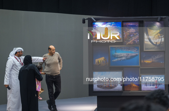 People look at photographs on display during the inaugural Doha Photography Festival 2024 at Darb al-Saai in Umm Salal, Qatar, on November 8...