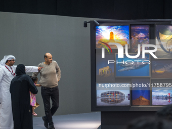 People look at photographs on display during the inaugural Doha Photography Festival 2024 at Darb al-Saai in Umm Salal, Qatar, on November 8...