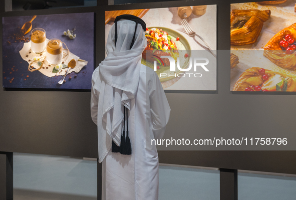 A Qatari boy looks at photographs during the inaugural Doha Photography Festival 2024 at Darb Al-Sai in Umm Salal, Qatar, on November 8, 202...