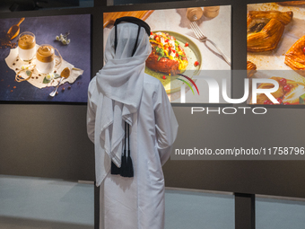 A Qatari boy looks at photographs during the inaugural Doha Photography Festival 2024 at Darb Al-Sai in Umm Salal, Qatar, on November 8, 202...