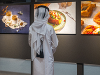 A Qatari boy looks at photographs during the inaugural Doha Photography Festival 2024 at Darb Al-Sai in Umm Salal, Qatar, on November 8, 202...