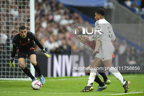 Jude Bellingham central midfield of Real Madrid and England and Ante Budimir centre-forward of Osasuna and Croatia compete for the ball duri...