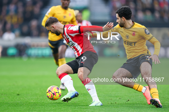 Number 9, Adam Armstrong of Southampton, and number 3, Rayan Ait-Nouri of Wolves, battle for the ball during the Premier League match betwee...