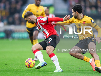 Number 9, Adam Armstrong of Southampton, and number 3, Rayan Ait-Nouri of Wolves, battle for the ball during the Premier League match betwee...