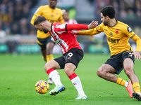 Number 9, Adam Armstrong of Southampton, and number 3, Rayan Ait-Nouri of Wolves, battle for the ball during the Premier League match betwee...